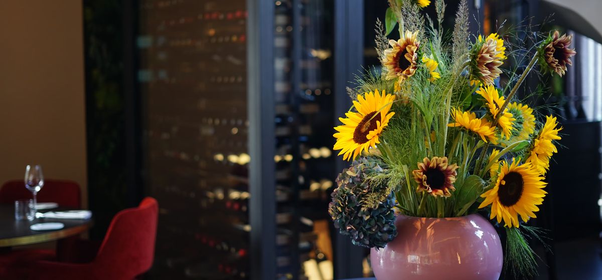 Inside the restaurant: sunflowers and a wall of wine